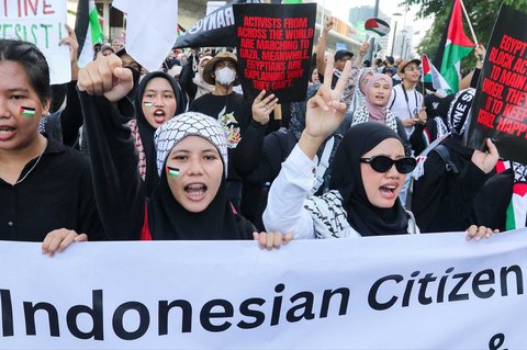 Peserta aksi mengikuti aksi long march dari depan Kedubes Amerika Serikat   hingga Bunderan HI, Jakarta, Minggu (15/06/2025).