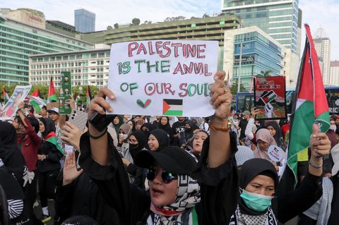 Peserta aksi mengikuti aksi long march dari depan Kedubes Amerika Serikat   hingga Bunderan HI, Jakarta, Minggu (15/06/2025).