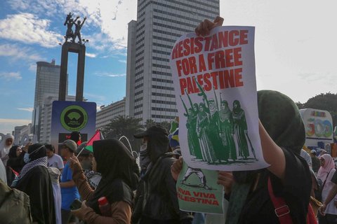 Peserta aksi mengikuti aksi long march dari depan Kedubes Amerika Serikat   hingga Bunderan HI, Jakarta, Minggu (15/06/2025).