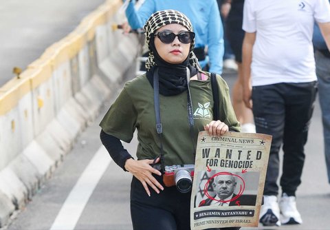 Peserta aksi mengikuti aksi long march dari depan Kedubes Amerika Serikat   hingga Bunderan HI, Jakarta, Minggu (15/06/2025).