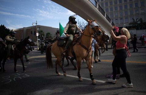 Seorang demonstran berdiri di depan pasukan berkuda sheriff Los Angeles  saat aksi  menentang Presiden AS Donald Trump di Los Angeles, California, AS, Sabtu (14/06/2025) waktu setempat