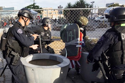 Petugas LAPD memukul seorang demonstran saat aksi  menentang Presiden AS Donald Trump di Los Angeles, California, AS, Sabtu (14/06/2025) waktu setempat.
