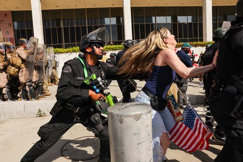 Petugas LAPD mendorong seorang demonstran saat aksi  menentang Presiden AS Donald Trump di Los Angeles, California, AS, Sabtu (14/06/2025) waktu setempat.