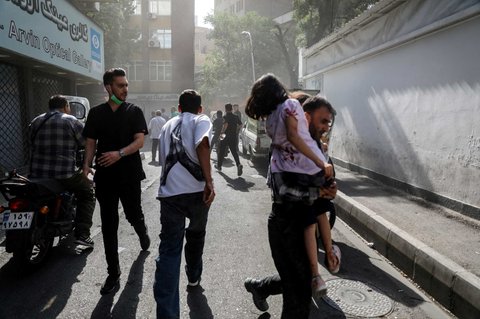 Sejumlah warga berlarian sesaat setelah serangan rudal Israel menghantam Kota Teheran, Iran, pada Minggu (15/6/2025).