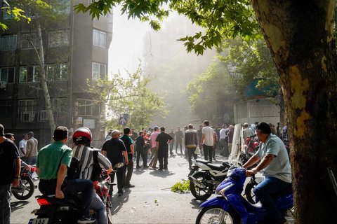Sejumlah warga berlarian sesaat setelah serangan rudal Israel menghantam Kota Teheran, Iran, pada Minggu (15/6/2025).