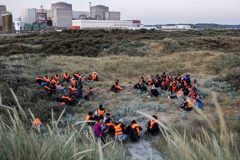Para migran bersembunyi di bukit pasir  menunggu untuk menaiki perahu penyelundup dalam upaya menyeberangi Selat Inggris di lepas pantai Gravelines, Prancis utara, (16/06/2025).
