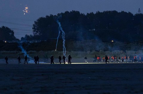 Petugas Korps Keamanan Republik Prancis (CRS) melemparkan gas air mata ke arah para migran untuk mencegah mereka menaiki perahu penyelundup dalam upaya menyeberangi Selat Inggris di lepas pantai Gravelines, Prancis utara, (16/06/2025)