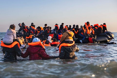 Para migran berlari ke air untuk menaiki perahu dalam upaya menyeberangi Selat Inggris di lepas pantai Gravelines, Prancis utara, (16/06/2025).