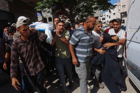 Keluarga  berduka di dekat jenazah warga Palestina yang tewas sehari sebelumnya akibat tembakan Israel saat antri mendapatkan bantuan pangan, di kamar mayat rumah sakit Al-Shifa di Kota Gaza, Rabu (18/06/2025).