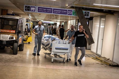 Dokter mendorong pasien ke tempat aman setelah rumah sakit Soroka terkena rudal Iran di Beersheba, Israel, (19/06/2025)