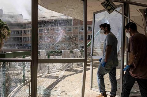 Staf rumah sakit berjalan melewati pintu yang hancur di rumah sakit Soroka yang  terkena rudal Iran di Beersheba, Israel, (19/06/2025)
