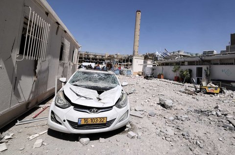 Mobil yang rusak diantara puing-puing di luar Rumah Sakit Soroka yang terkena rudal Iran di Beersheba, Israel, (19/06/2025)