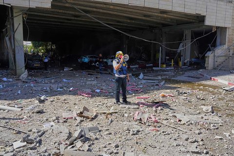 Tim tanggap darurat Israel memperingatkan warga di lokasi serangan rudal  Iran  di Haifa, Israel, Jumat (20/06/2025).
