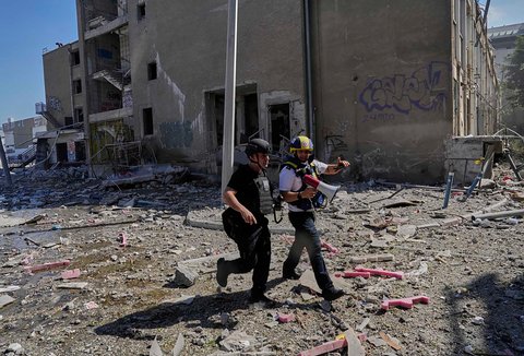 Pasukan keamanan Israel dan tim tanggap darurat bekerja di samping gedung yang terkena serangan rudal Iran di Haifa, Israel, Jumat (20/06/2025).