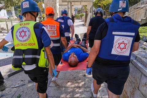 Seorang pria yang terluka dievakuasi dari lokasi serangan rudal  Iran  di Haifa, Israel, Jumat (20/06/2025).
