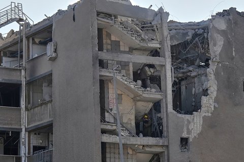 Tim tanggap darurat Israel memperingatkan warga di lokasi serangan rudal  Iran  di Haifa, Israel, Jumat (20/06/2025).<br /> AP/Baz Ratner