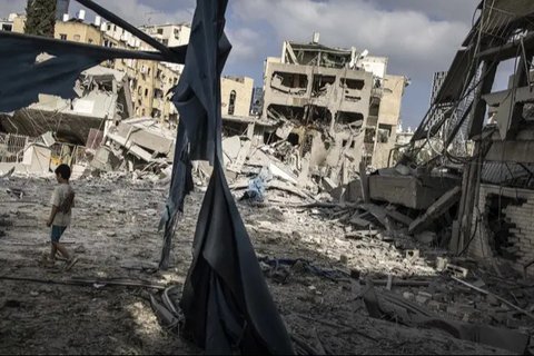 Petugas tanggap darurat Israel berdiri di antara puing-puing bangunan yang rusak berat, setelah serangan rudal Iran semalam di Bat Yam pada 15 Juni 2025. (GIL COHEN-MAGEN/AFP)