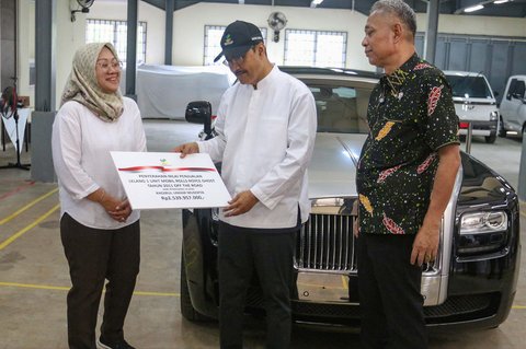 Menteri Sosial Saifullah Yusuf didampingi Wakil Menteri Sosial Agus Jabo secara simbolis menyerahkan bukti pemenang lelang mobil mewah Roll-Royce kepada perwakilan pemenang lelang di Gudang Kompleks Taman Makam Pahlawan Kalibata, Jakarta, Selasa (24/6/2025).