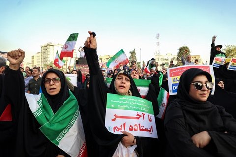 Warga Iran meneriakkan slogan dan mengibarkan bendera saat merayakan gencatan senjata antara Iran dan Israel di Lapangan Enghelab, Teheran, pada Selasa (24/6/2025).