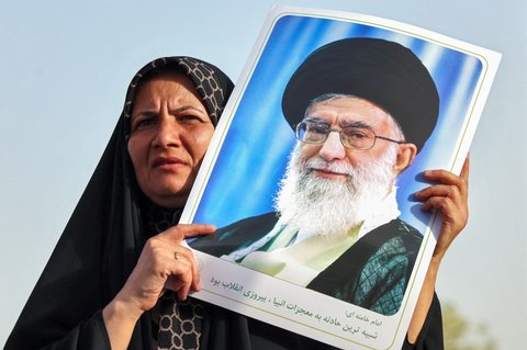 Warga Iran meneriakkan slogan dan mengibarkan bendera saat merayakan gencatan senjata antara Iran dan Israel di Lapangan Enghelab, Teheran, pada Selasa (24/6/2025).