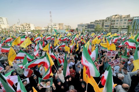 Warga Iran meneriakkan slogan dan mengibarkan bendera saat merayakan gencatan senjata antara Iran dan Israel di Lapangan Enghelab, Teheran, pada Selasa (24/6/2025).