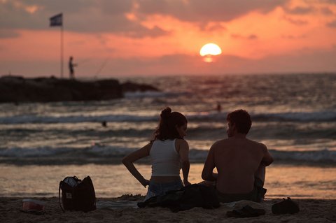 Aktifitas warga Israel saat matahari terbenam (sunset)  usai gencatan senjata yang mengakhiri perang dengan Iran  di pantai di Tel Aviv, Israel (24/06/2025).