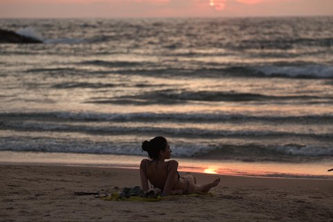 Aktifitas warga Israel saat matahari terbenam (sunset)  usai gencatan senjata yang mengakhiri perang dengan Iran  di pantai di Tel Aviv, Israel (24/06/2025).