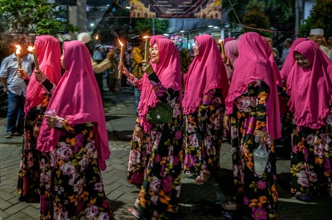 Kaum ibu mengikuti pawai obor menandai dimulainya Tahun Baru Islam 1 Muharram 1447 Hijriah di Surabaya, (26/06/2025).