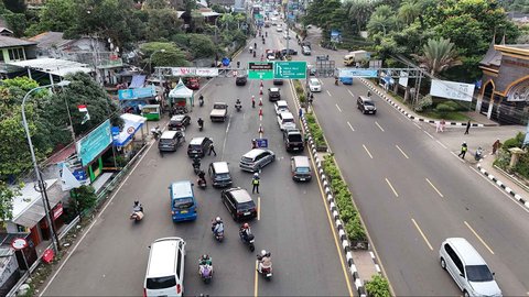 Petugas melakukan penyekatan ganjil genap kepada pengendara yang akan menuju kawasan Puncak di Gadog, Bogor, Sabtu (28/6/2025).