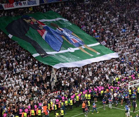 Suporter PSG membentangkan poster bergambar Luis Enrique dan mendiang putrinya, Xana setelah laga final Liga Champions 2024/2025 melawan Inter Milan di Allianz Arena, Munchen, Jerman, Minggu (01/06/2025) dini hari WIB. (AFP Kirill Kudryavtsev)