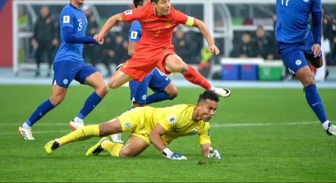 Aksi bintang Timnas China, Wu Lei (merah) saat menghadapi hadangan dari kiper Timnas Singapura, Hassan Sunny di putaran kedua Kualifikasi Piala Dunia 2026. (AFP).