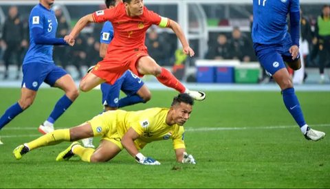 Aksi bintang Timnas China, Wu Lei (merah) saat menghadapi hadangan dari kiper Timnas Singapura, Hassan Sunny di putaran kedua Kualifikasi Piala Dunia 2026. (AFP).