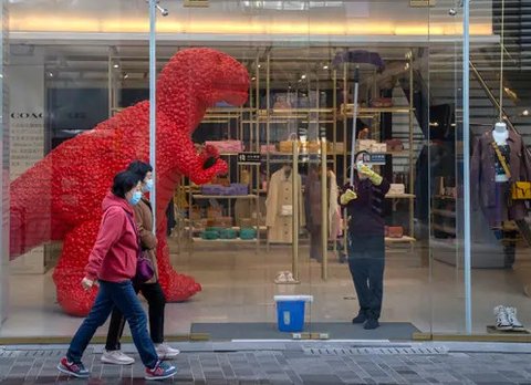 Seorang pekerja membersihkan pintu kaca toko barang mewah di sebuah pusat perbelanjaan di Beijing, China, Senin (6/3/2023). Pejabat ekonomi China menyatakan keyakinannya bahwa mereka dapat me