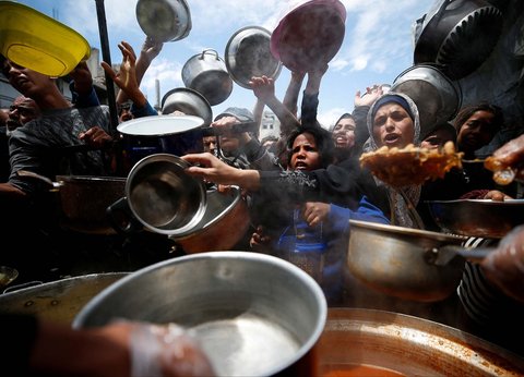 Warga Palestina antri mengambil  makanan yang dimasak di  Dapur Amal, di Beit Lahiya, Jalur Gaza utara, Senin (28/04/2025).