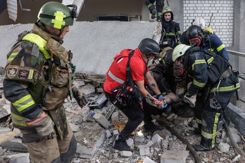 Tim penyelamat dan paramedis membawa seorang warga yang terluka akibat tertimpa reruntuhan bangunan yang terkena serangan drone Rusia di Kharkiv, Ukraina, Sabtu (07/06/2025).