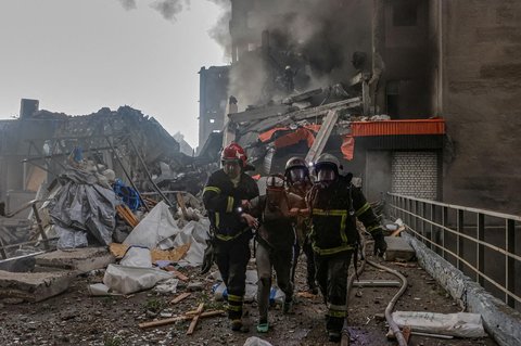 Tim penyelamat dan paramedis membawa seorang warga yang terluka akibat tertimpa reruntuhan bangunan yang terkena serangan drone Rusia di Kharkiv, Ukraina, Sabtu (07/06/2025).