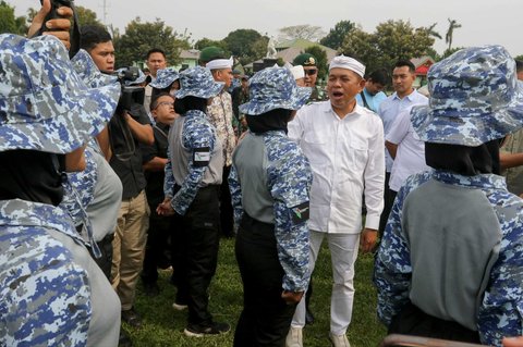 Gubernur Jawa Barat, Dedi Mulyadi berbincang dengan pelajar yang mengikuti Pendidikan Bela Negara saat acara penutupan di Markas Kostrad, Cilodong, Depok, Jawa Barat, Senin (9/6/2025).