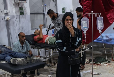 Warga Palestina duduk di sekitar jenazah keluarganya  yang tewas dalam tembakan Israel di titik distribusi bantuan pangan yang didirikan oleh Yayasan Kemanusiaan Gaza (GHF) di rumah sakit Al-Awda di kamp pengungsi Nuseirat di Jalur Gaza tengah, Palestina, Selasa (24/06/2025)