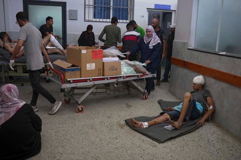 Staf rumah sakit membawa kotak-kotak berisi perlengkapan pasien yang yang terluka akibat serangan Israel di Rumah Sakit Shifa di Kota Gaza, Minggu,  (06/07/2025).