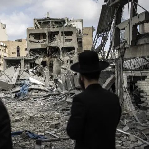 Warga mengamati apartemen yang rusak di Teheran, Iran, akibat serangan udara Israel pada Jumat (13/6/2025). (Dok. AP/Vahid Salemi)