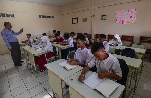Murid tingkat SMP  dalam program Rintisan Sekolah Swasta Gratis belajar dalam kelas saat kegiatan MPLS (Masa Pengenalan Lingkungan Sekolah) di SMP Tarbiyah Islamiyah, Depok, Jawa Barat, Senin (14/07/2025).