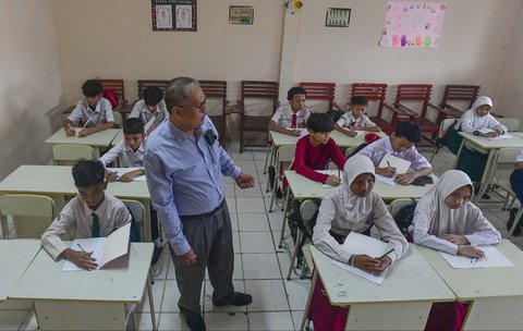 Murid tingkat SMP  dalam program Rintisan Sekolah Swasta Gratis belajar dalam kelas saat kegiatan MPLS (Masa Pengenalan Lingkungan Sekolah) di SMP Tarbiyah Islamiyah, Depok, Jawa Barat, Senin (14/07/2025).