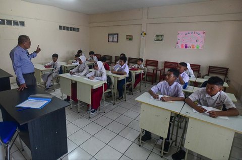 Murid tingkat SMP  dalam program Rintisan Sekolah Swasta Gratis belajar dalam kelas saat kegiatan MPLS (Masa Pengenalan Lingkungan Sekolah) di SMP Tarbiyah Islamiyah, Depok, Jawa Barat, Senin (14/07/2025).
