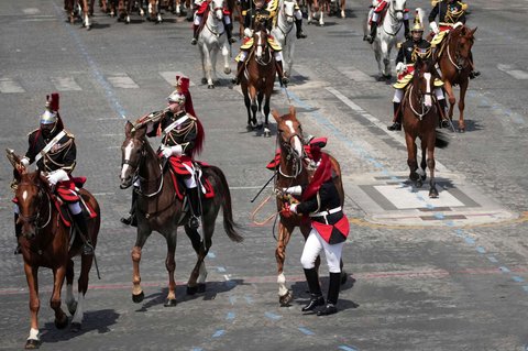 Seorang prajurit menangani kuda yang tergelincir saat parade militer Bastille Day di Paris, Prancis, pada Senin (14/7/2025).