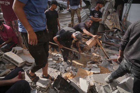 Warga Palestina mencari korban selamat dan jenazah di antara reruntuhan bangunan yang hancur akibat serangan udara Israel di Kota Gaza, Selasa, (15/07/2025).