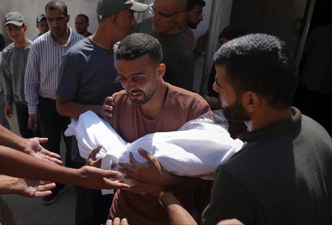 Seorang ayah memeluk jenazah anaknya, yang tewas akibat  serangan udara militer Israel di Rumah Sakit Shifa di Kota Gaza, Selasa, (15/07/2025).
