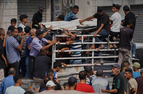 Warga  membawa jenazah warga Palestina yang tewas akibat serangan udara Israel saat pemakaman di Rumah Sakit Shifa di Kota Gaza, Selasa, (15/07/2025).