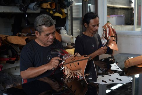 Perajin sedang mengerjakan sepasang sepatu bot kulit untuk pasar AS di bengkel Tegep Boots di Bandung, Jawa Barat, Selasa (15/07/2025).