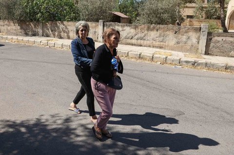 Warga berlarian di jalan saat mereka meninggalkan rumah mereka di tengah bentrokan antara pejuang Druze dan suku Badui di kota Suwayda, Suriah, Rabu (16.07/2025).