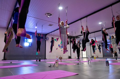 Para perempuan berlatih yoga udara dalam sebuah sesi di sebuah pusat kebugaran khusus perempuan di Banda Aceh, Sabtu (19/07/2025).